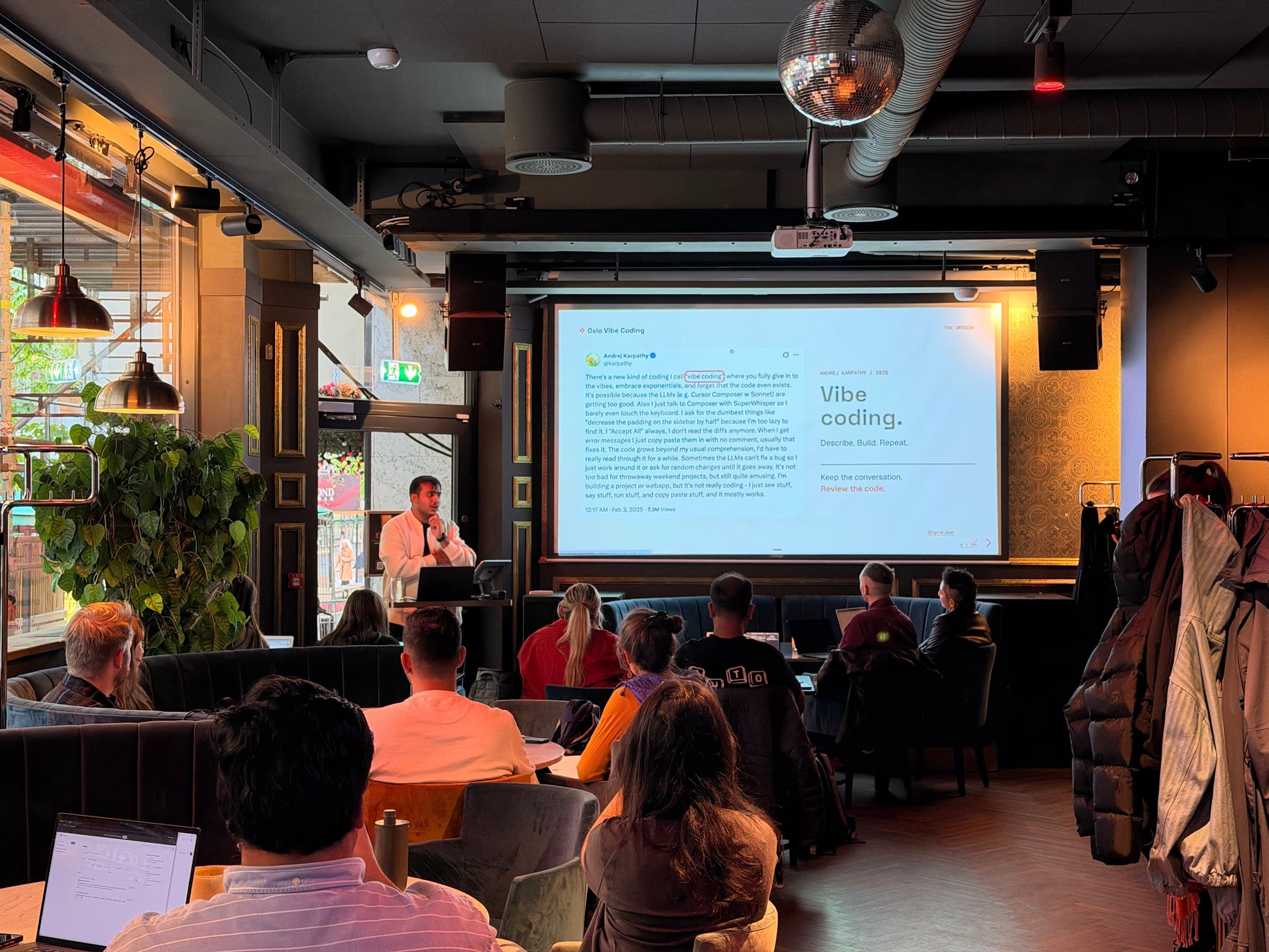 A presenter introducing vibe coding to a full room of workshop participants